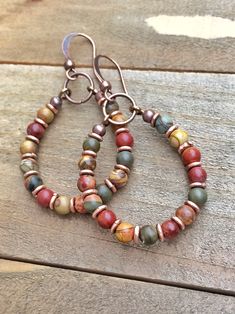 "Bohemian hoop earrings with red creek jasper and antiqued copper. Light-weight, earthy and colorful small hoop earrings with rustic, antiqued copper accents. Red creek jasper is a beautiful stone that contains a variety of colors from reds and oranges to blues and greens. Perfect everyday earrings that are sure to go with almost all of your wardrobe! Product overview: - Made with red creek jasper and antiqued copper - Total hanging length approximately 1.75\" - Light-weight, colorful and versat Bohemian Rust Earrings With Ear Wire, Bohemian Brown Wire Wrapped Hoop Earrings, Brown Copper Bohemian Hoop Earrings, Handmade Rust-colored Earthy Earrings, Rustic Handmade Hoop Earrings, Boho Jewelry Diy, Boho Hoop Earrings, Earthy Jewelry, Colorful Earrings