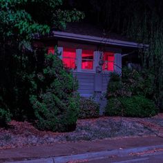 a red light shines in the window of a small house