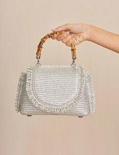 Cult Gaia Ozzy Mini Top Handle Bag in silver. Bamboo top handle. Woven raffia body. Fringe trim. Silver toned purse feet. Metallic coated raffia. W 3.94" X H 5.71" X L 8.66". HANDLE DROP: 2.91". 52% Cotton, 48% Polyamide. Trim: 100% Cow Leather. Lining: 90% Polyester, 10% Polyurethane. Imported. Mini Top Handle Bag, Rococo Sand, Bamboo Top, Mini Top, Woven Raffia, Cult Gaia, Pumps Flat, Scarf Jewelry, Fringe Trim