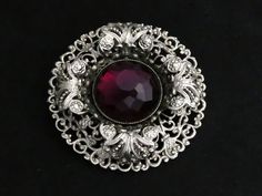 VINTAGE - beautiful, large silvertone layered filigree brooch with curled 3D leaf design and unusual deep purple domed shaped soft faceted glass stone. Nice clean condition. Clasp:     Roll over clasp and pin intact Signed:   Unsigned SIZE: Approx: 5 cm x 5 cm x 1.5 cm height CONDITION:  Good Vintage Condition Ornate Brooches With Intricate Design For Formal Occasions, Vintage Brooches With Intricate Design For Formal Occasions, Vintage Round Brooch With Intricate Design, Vintage Round Brooches With Intricate Design, Vintage Filigree Brooches For Formal Occasions, Antique Silver Ornate Brooch For Formal Occasions, Ornate Antique Silver Brooches For Formal Occasions, Ornate Antique Silver Brooch For Formal Occasions, Ornate Silver Brooches For Evening