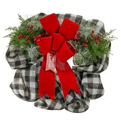 a christmas wreath with red bows and evergreens on it, sitting in front of a white background