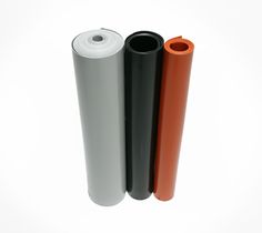 three different colored plastic tubes on a white background, one is orange and the other is black