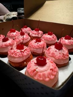 there are many cupcakes with pink frosting and cherries on the top