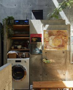 a washer sitting next to a dryer in a room with concrete walls and flooring