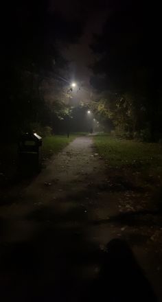 an empty path in the middle of a park at night