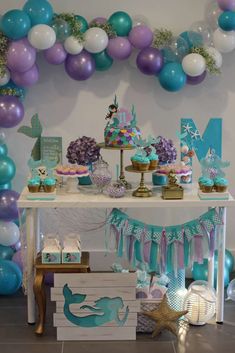 an under the sea themed party with balloons and mermaid cake, cupcakes and decorations