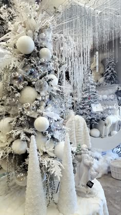 the snow covered trees are decorated with white ornaments