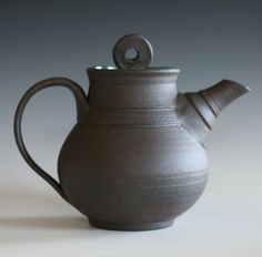 a gray ceramic tea pot with a handle