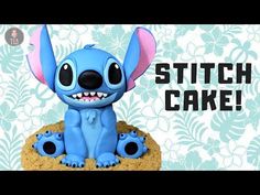 a small blue toy sitting on top of a cookie with the words stitch cake written above it