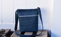 a blue denim bag sitting on top of a wooden pallet next to a white wall