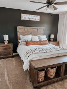 a bedroom with a large bed and two baskets on the end tables in front of it