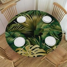 the table is set with white plates and place settings for four people to sit at