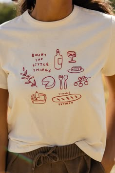 The cutest graphic tee is here! Featuring a little picnic on your shirt, the Enjoy The Little Things Tee is a cute take on a classic graphic. slightly sheer // paired with the come together tapered pants in darkolivegreen Vintage Graphic Tees Women, T Shirts Trendy, Popular T Shirts Graphic Tees, Positive Quotes Tshirt, Etsy Tee Shirts, Fun T Shirt Ideas, Cow Graphic Tee, Women’s Tshirts Graphic, Motivational Graphic Tees