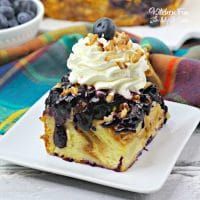 a piece of cake on a plate with blueberries