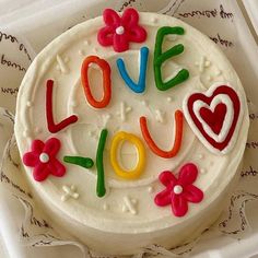 a decorated cake with the words love you spelled in frosting and flowers on top