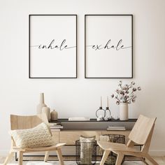 two framed art prints on the wall above a coffee table with chairs and vases