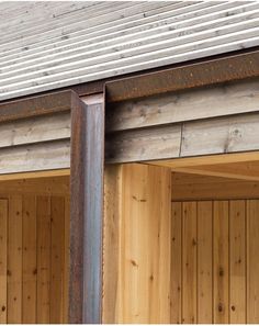 an open garage door with wood paneling on the outside and metal frame around it