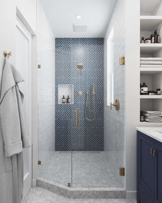 a walk in shower sitting next to a blue cabinet and white counter top under a window