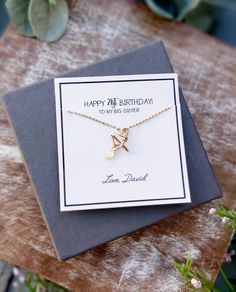 a birthday card with a gold initial charm