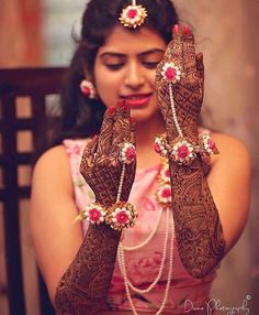 a woman holding up her hands with henna on it