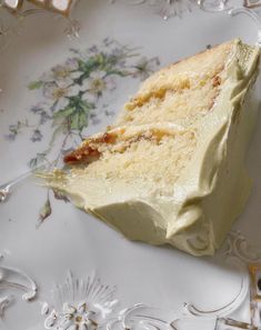 a piece of cake sitting on top of a white and gold plate covered in frosting