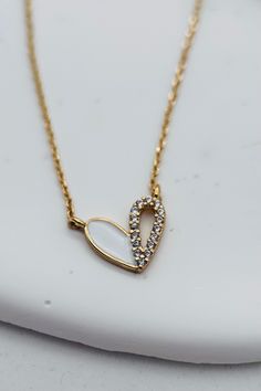 This dainty Tiny Heart Necklace features a delicate gold and white accent adorned with tiny rhinestones. The delicate chain includes an extender for a customizable fit. Elevate any outfit with this elegant and timeless piece. Length: 16" Extender Chain: 2" Finish: Gold Plating Product: Cubic Zirconia White Chain Necklace For Valentine's Day Gift, Heart-shaped White Chain Necklace For Gift, White Chain Necklace With Adjustable Chain For Valentine's Day, White Adjustable Chain Necklace For Valentine's Day, Gold Plated Heart Necklace With Delicate Chain For Wedding, Dainty White Heart Pendant Necklace, Dainty White Heart-shaped Necklace, Elegant White Chain Necklace For Valentine's Day, White Heart Necklace With Chain