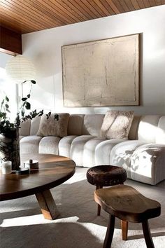 a living room filled with furniture and a large painting hanging on the wall above it