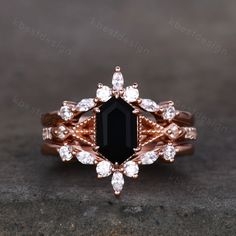 an engagement ring set with black onyxite and white diamonds in 18k rose gold