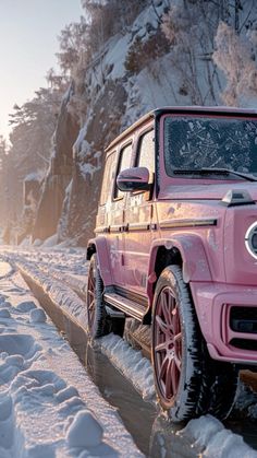 a pink jeep driving down a snow covered road