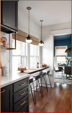 a kitchen with wooden floors and black cabinets