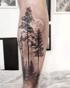 a man's leg with trees and the moon on it