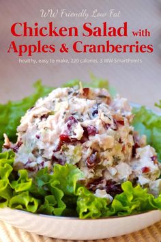 chicken salad with apples and cranberries in a white bowl on top of lettuce