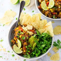 two bowls filled with mexican food and tortilla chips