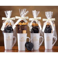 four coffee mugs wrapped in clear cellophane and tied with white ribbon