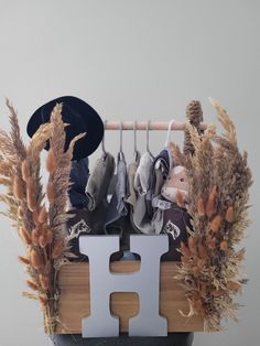 a wooden rack with shoes and hats hanging from it's sides next to dry grass