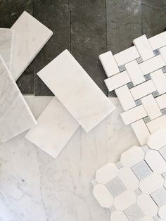 several white and grey tiles laying on top of each other in the middle of a floor