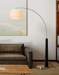 a living room with a couch, lamp and bookshelf on the wall behind it