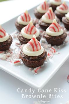 chocolate cupcakes with white frosting and candy canes on a square plate