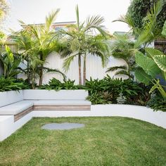 a white bench sitting in the middle of a lush green yard