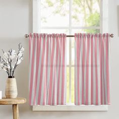 a pink and white striped curtain hanging on a window sill next to a vase with flowers