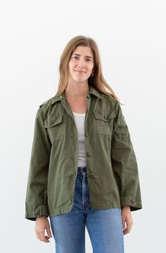 "Olive green jacket shirt with button closure and two front chest pockets, epaulettes. Maker: Military  |  Made in USA.  |  Material: Cotton Poplin Condition: Excellent.   X-SMALL: Shoulders: 16\"  |  Chest: 19\"  |  Length: 25\"  |  Sleeve: 22\" SMALL: Shoulders: 16.5\"  |  Chest: 21\"  |  Length: 25\"  |  Sleeve: 22\" Alex is 5'5\" and wears a modern small. She is wearing the X-SMALL here. SHOP http://www.rawsonstudio.etsy.com FOLLOW US + instagram | @_rawson + pinterest | rawson **No Returns. Items are eligible for store credit only. We ask that the buyer ship to provided address and a credit code is issued for one year.**" Military Style Cotton Utility Jacket With Buttoned Pockets, Military Style Khaki Utility Jacket With Buttoned Pockets, Green Outerwear With Patch Pockets For Fall, Green Utility Long Sleeve Outerwear, Military Style Utility Jacket With Patch Pockets For Spring, Military Utility Jacket With Patch Pockets For Spring, Military Style Long Sleeve Utility Jacket For Fall, Green Long Sleeve Utility Shacket, Khaki Utility Jacket With Patch Pockets