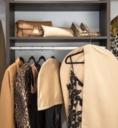 a closet with clothes and shoes hanging on the rack, including jackets and skirts in different colors