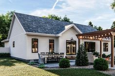 a small white house with an attached patio and pergolated seating area on the front lawn