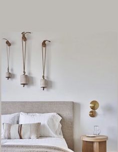 a bedroom with white walls and two lamps on the wall above the bed, along with an end table