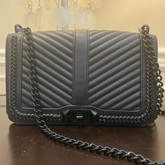 Rebecca Minkoff Chevron Quilted Love Crossbody With Chain Inset In Black Meet Your New Day-To-Night Bag! The Love Crossbody Is A Match Made In Heaven With Any Outfit. Wear It As Crossbody, As Shoulder Bag Or Remove The Chain Strap To Use It As A Clutch. Chevron Quilted Love Crossbody Comes With An Adjustable Pull-Through Chain Shoulder Strap, Signature Turn-Lock Hardware, A Back-Slip Pocket, And A Roomy Interior That Will Fit Your Essentials. Made From Smooth Leather With Chevron Quilting And Interwoven With Chain Trim, This Beauty Has A Fully Lined Interior With A Zip Pocket And Card Slot. - Detachable Chain And Leather Crossbody Strap - Quilted Design - Chain Inset, Brand Logo Hardware Luxury Black Bag For Night Out, Luxury Black Shoulder Bag For Night Out, A Match Made In Heaven, Rebecca Minkoff Bag, Chevron Quilt, Match Made In Heaven, Pull Through, Made In Heaven, Gorgeous Bags