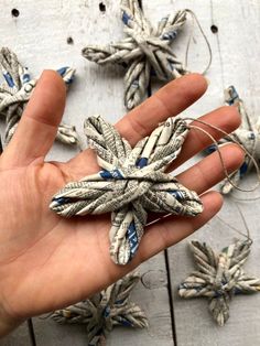 a hand is holding some silver and blue ornaments