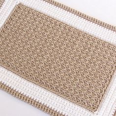 a close up of a rug on a white tablecloth with brown and white trim