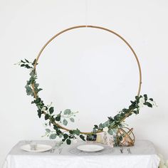 a table topped with plates and greenery