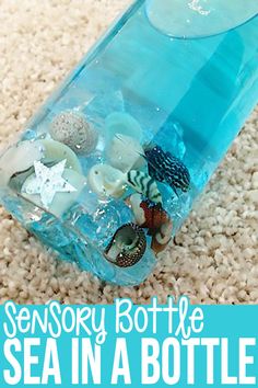 a bottle filled with sea shells on top of a carpet