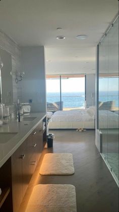 a bathroom with two sinks and a large window overlooking the ocean in front of it